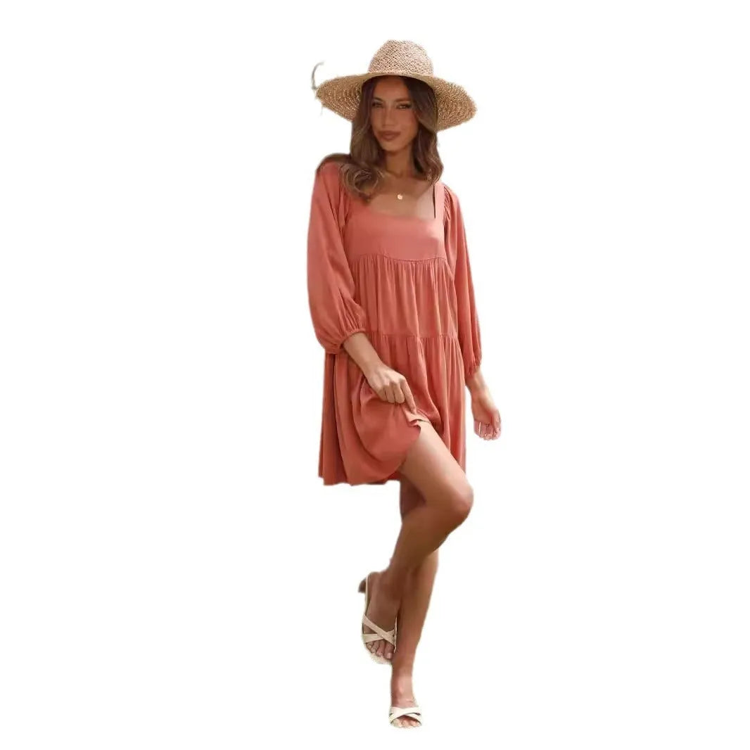 Orange backless children's dress with a square collar and puff sleeves on a mannequin.