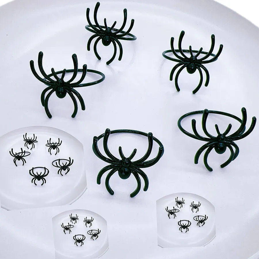 Set of six black alloy napkin rings with spider pattern design for Halloween table decoration