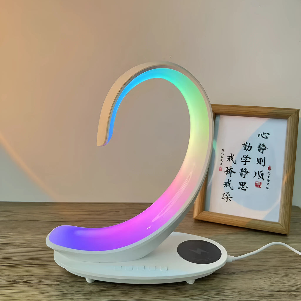 White swan-shaped desktop device with wireless charging pad, Bluetooth speaker, and colourful atmosphere lighting.