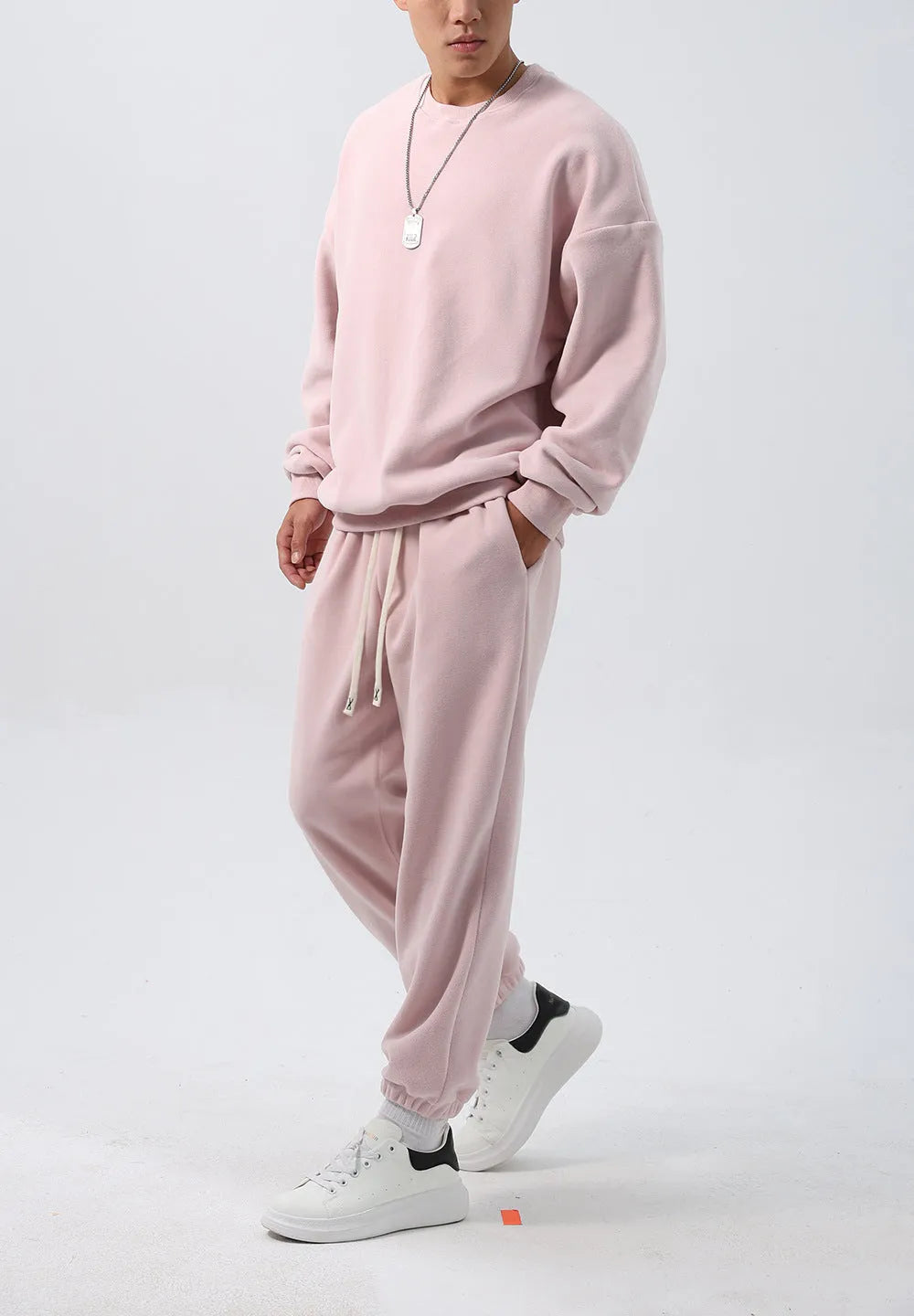 Men's black polar fleece sports suit with crew neck coat and matching trousers on a hanger.