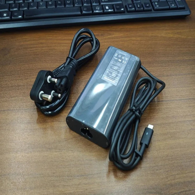 Black 65W USB-C laptop power adapter with six international plug cords for UK US EU AU SA and CN sockets