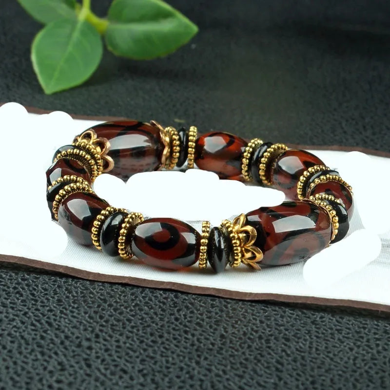 Distressed agate bracelet with traditional Tibetan dzi beads including three-eye and Nine Eyes designs.