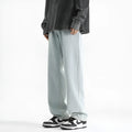 Men's light blue washed straight leg jeans with button waist on a neutral background.