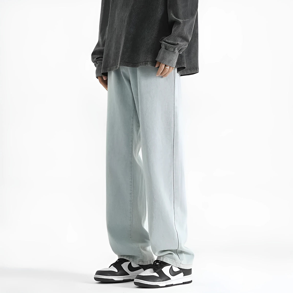 Men's light blue washed straight leg jeans with button waist on a neutral background.