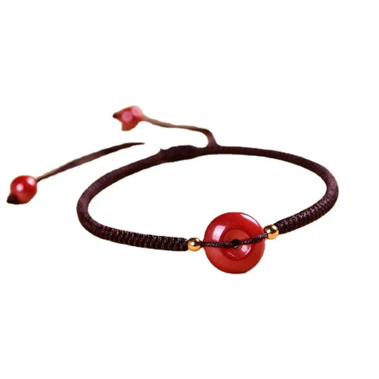 Cinnabar heart-shaped safety buckle bracelet with adjustable knot closure on wrist