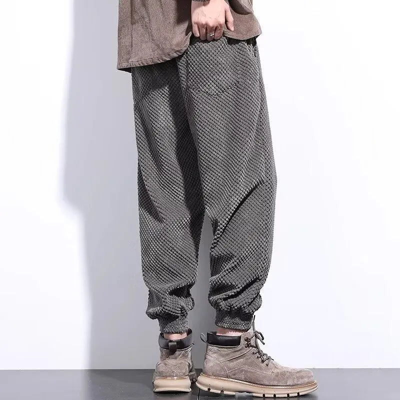 Men's grey ankle-tied straight-leg sweatpants laid flat, showing non-ironing polyester blend fabric.
