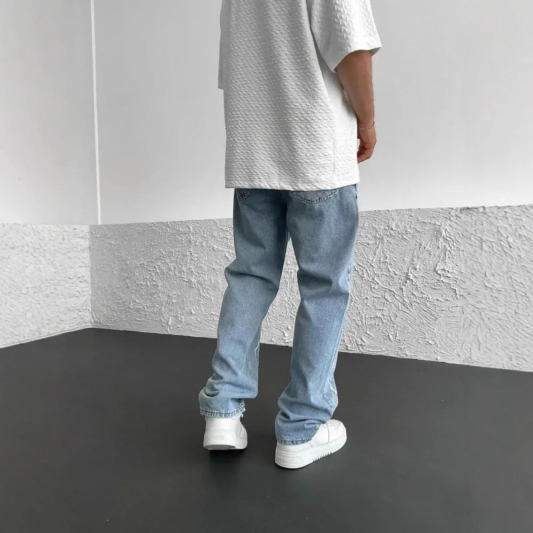 Men's blue straight-leg loose wide-leg denim jeans on a neutral background