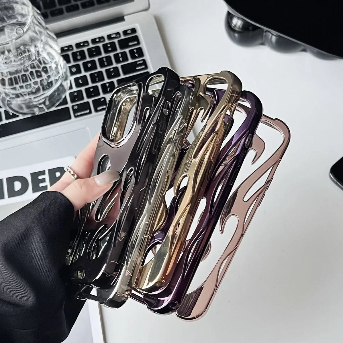 Electroplated hollow flame pattern iPhone case in silver TPU soft shell on a mobile phone.