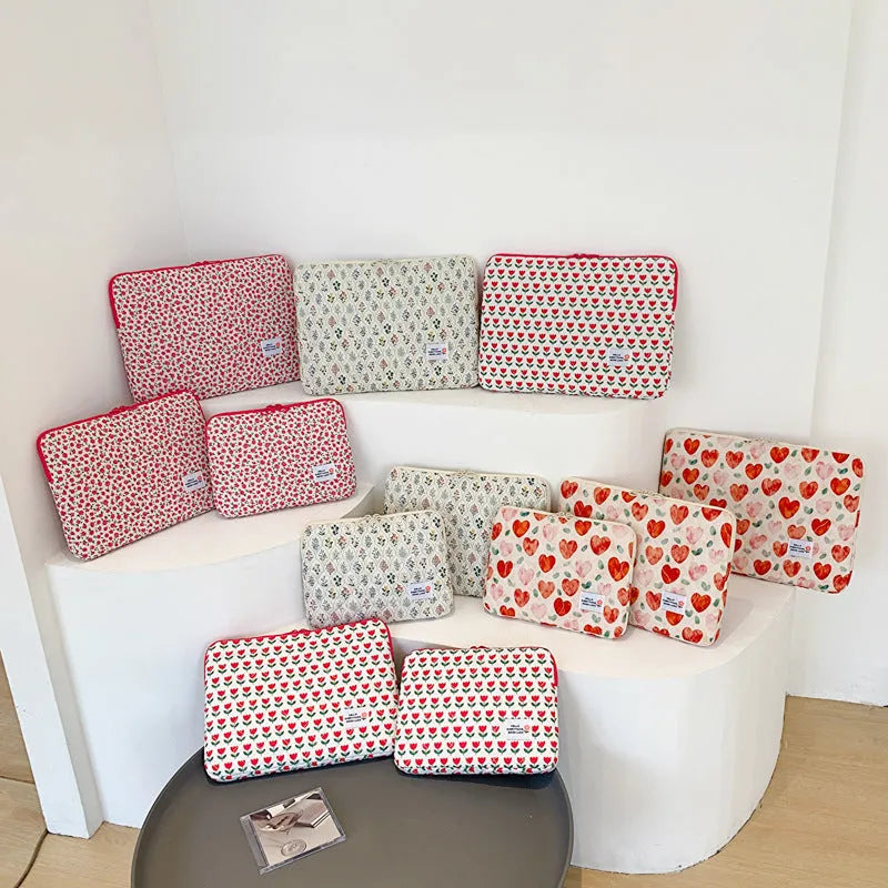 Printed cloth laptop bag for women shown in floral and heart patterns, available in small, medium, and large sizes.