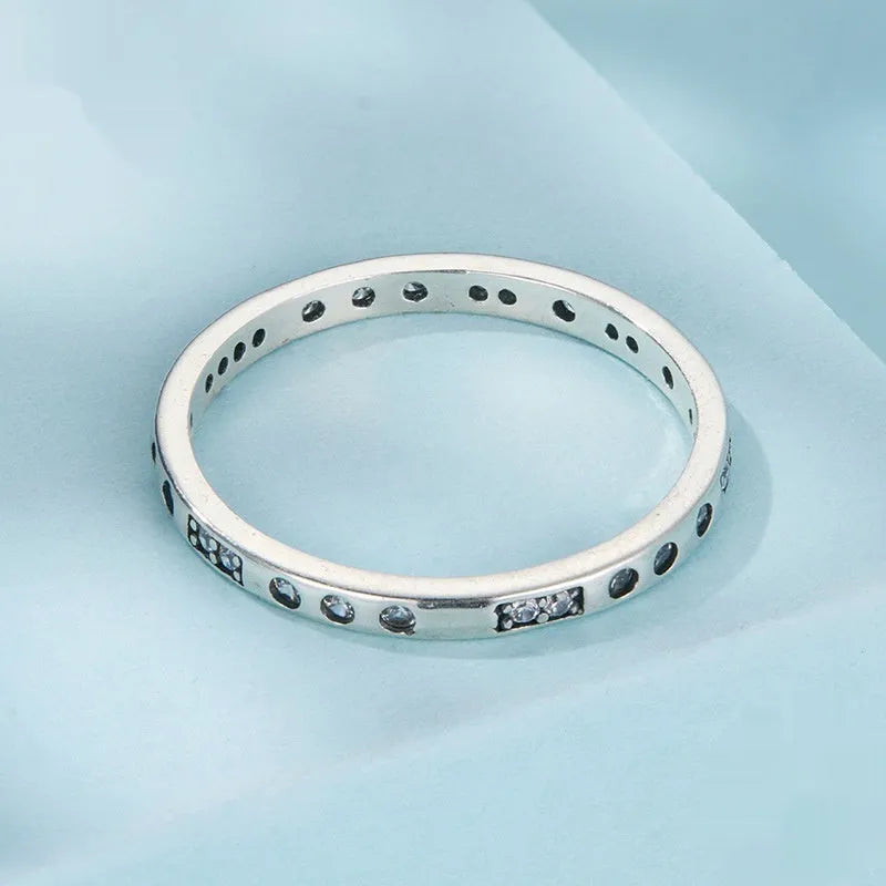 Sterling silver I Love You ring with oxidised black finish and moss knot design on a finger.
