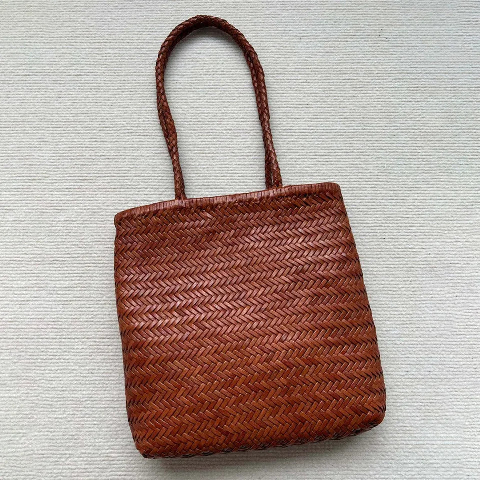 Brown woven genuine leather tote bag with a three-dimensional front pocket.