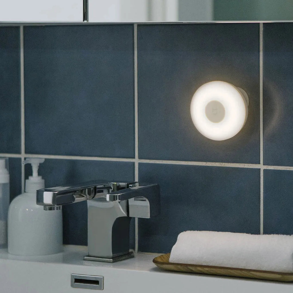 White Mijia Bluetooth bedside lamp with human body induction on a nightstand.