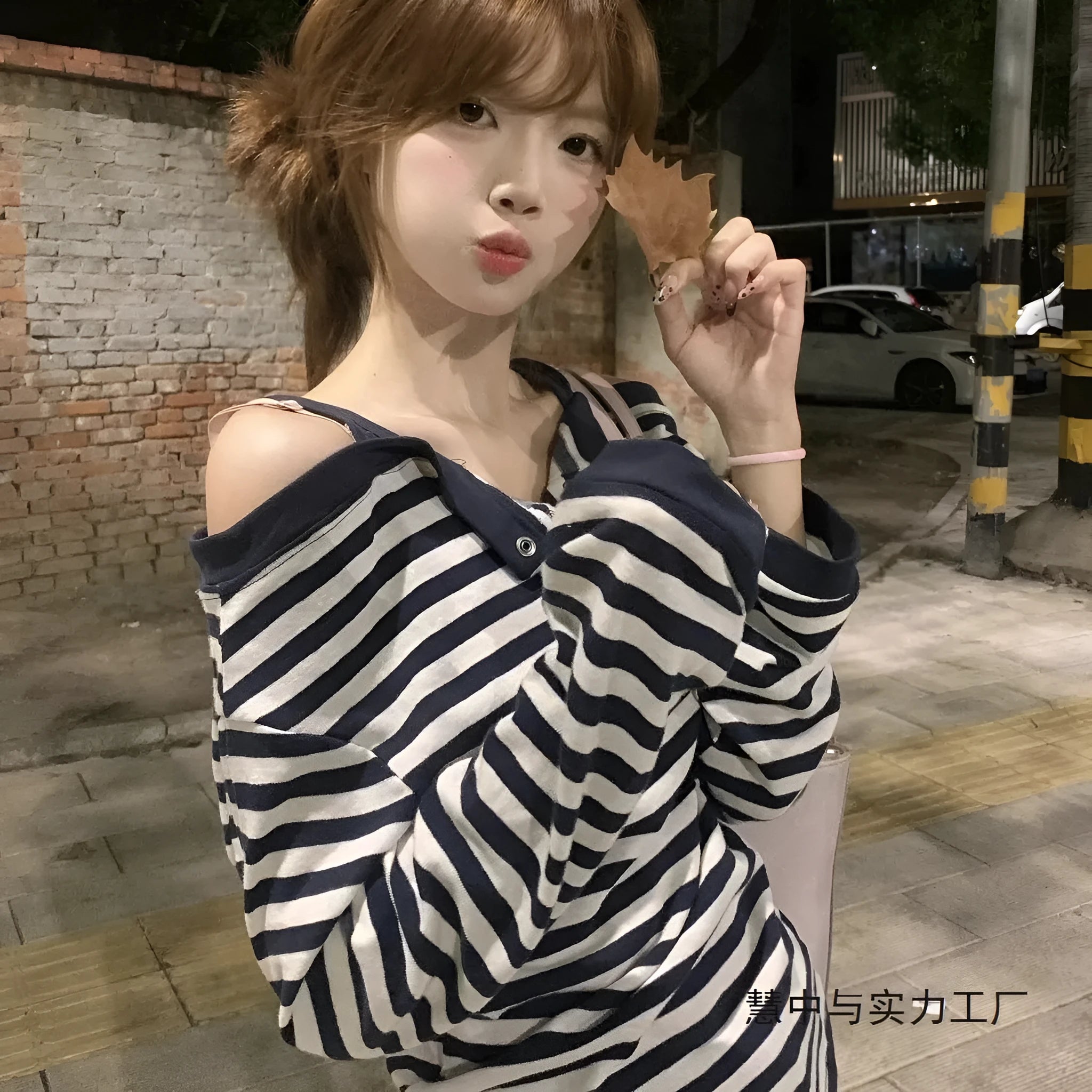 Dark blue oversized women's long-sleeved t-shirt with stripes and embroidery on a hanger.