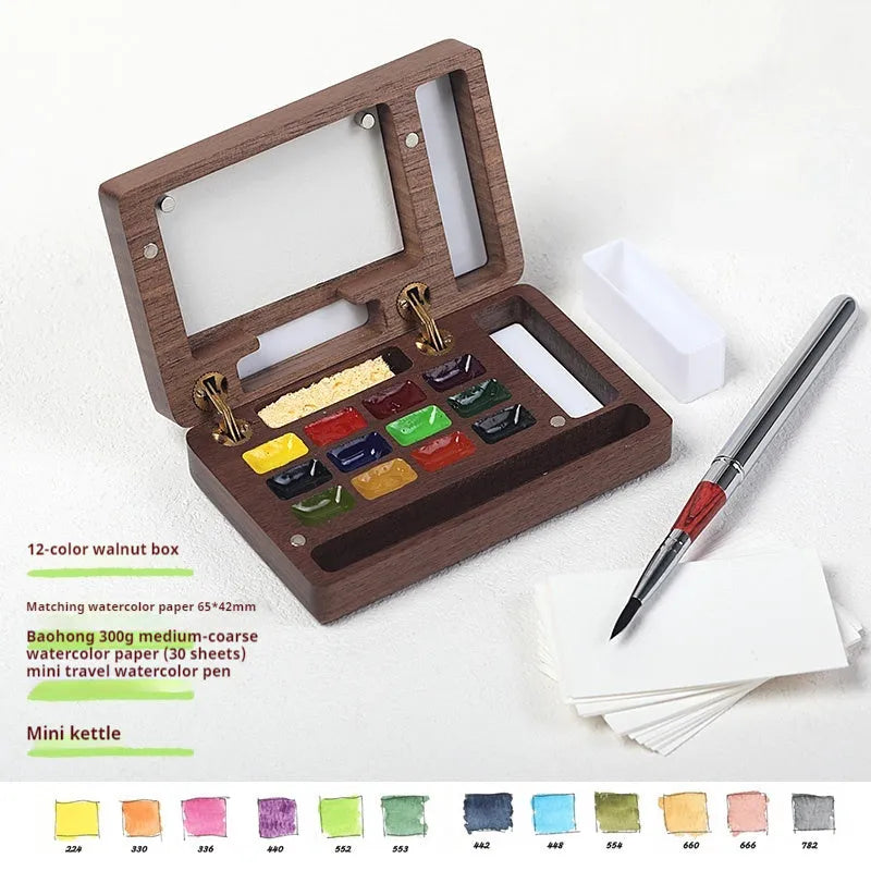 Mini solid walnut wood watercolour paint box with open lid showing internal compartments for half-pan pigments.