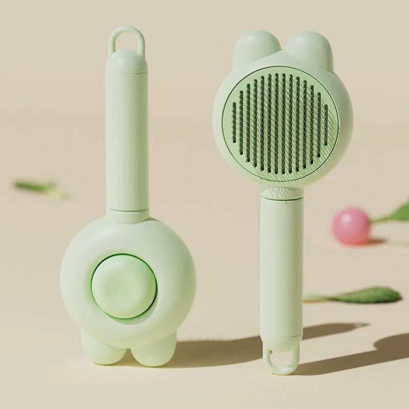 Green self-cleaning pet grooming brush with metal comb and comfort-grip handle on a wooden table.