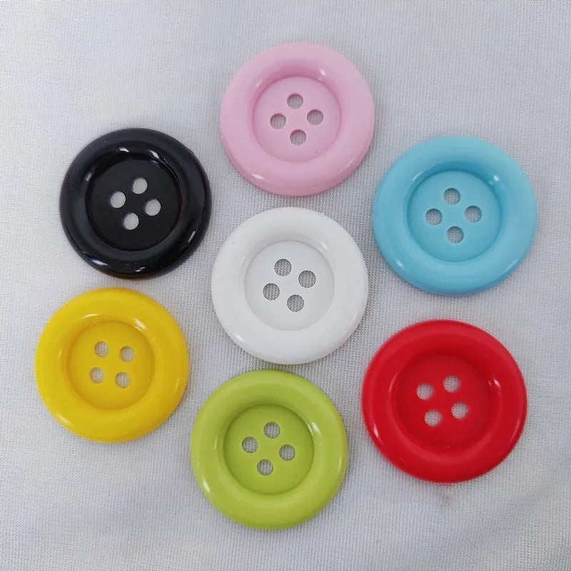 Assortment of oversized round plastic buttons in multiple colours showing four-hole design.