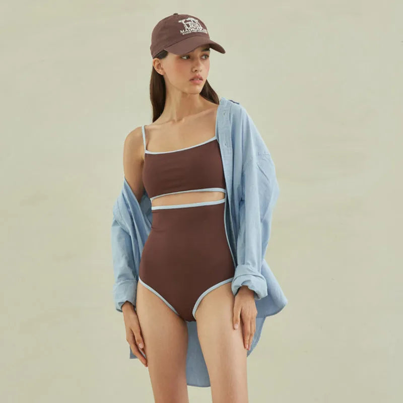 Brown women's one-piece swimsuit with triangle style on a hanger.