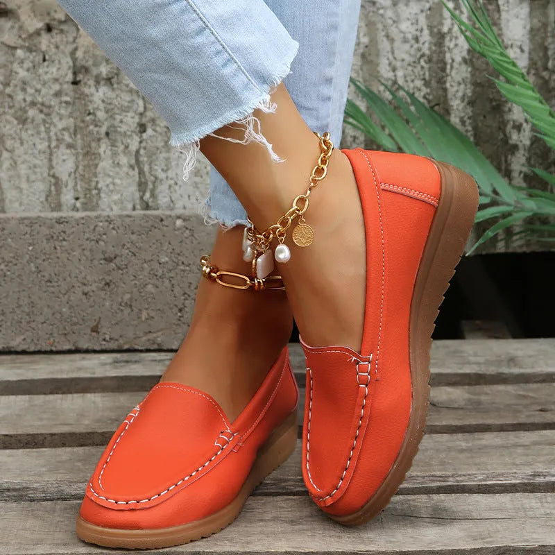Women's flat slip-on loafers in PU leather with car suture detailing on the upper.