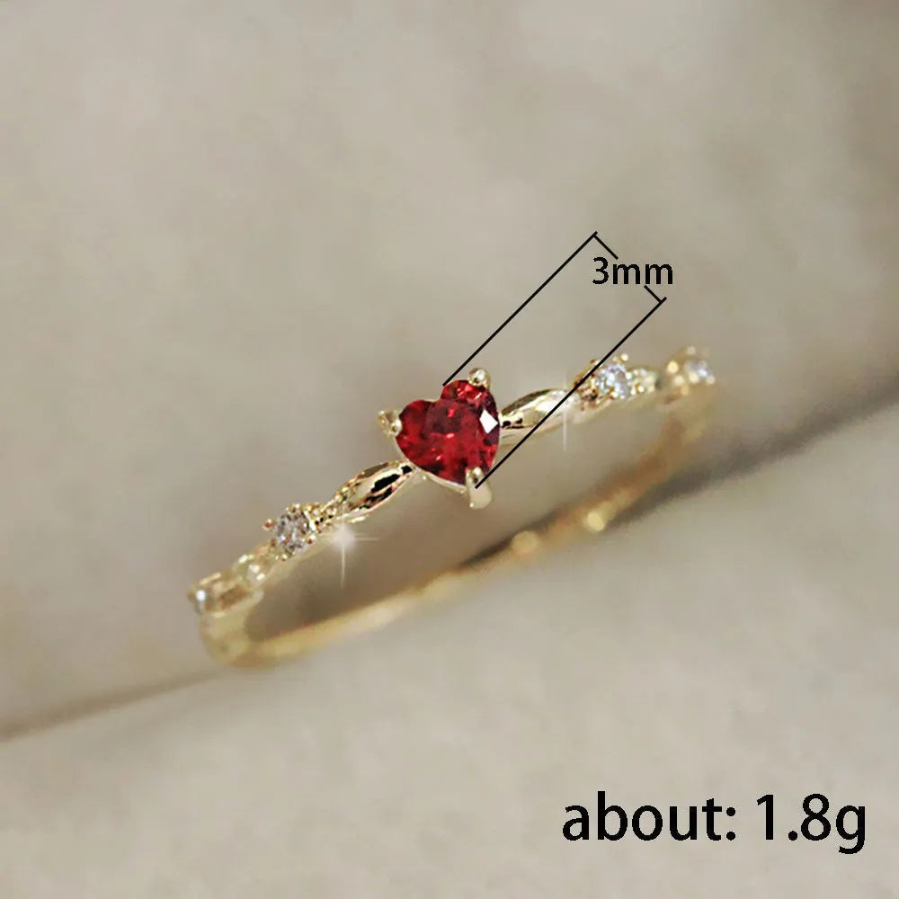 Gold or silver tone peach heart fashion ring with a zircon stone on a model finger.