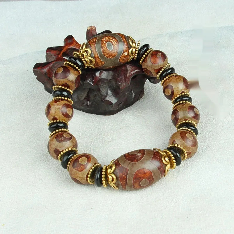 Distressed agate bracelet with traditional Tibetan dzi beads including three-eye and Nine Eyes designs.