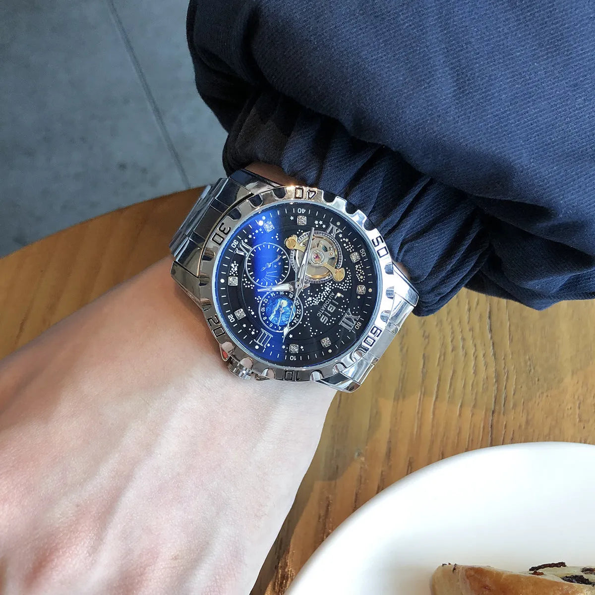 Men's silver automatic mechanical watch with black starry dial and luminous hands on steel strap