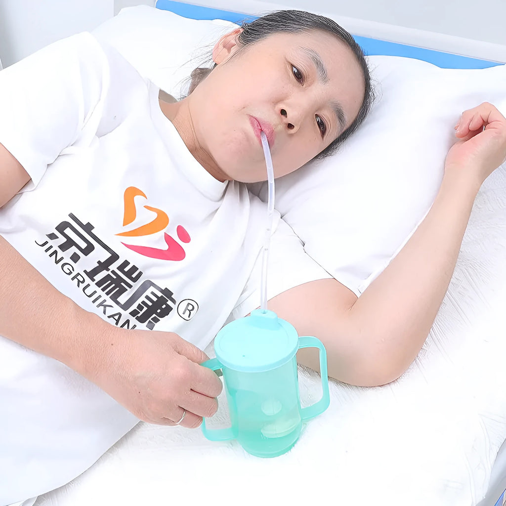 Adult care bed drinking cup with handle and lid, shown in oblique mouth choke proof style