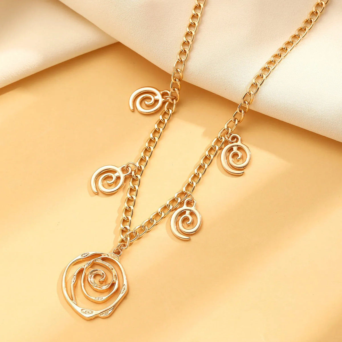 Gold or silver electroplated alloy jewellery set with spiral donut geometric shapes including necklace bracelet and ear hooks