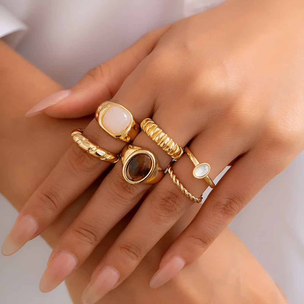 Six geometric alloy rings with light gold electroplated finish arranged as a coordinated set