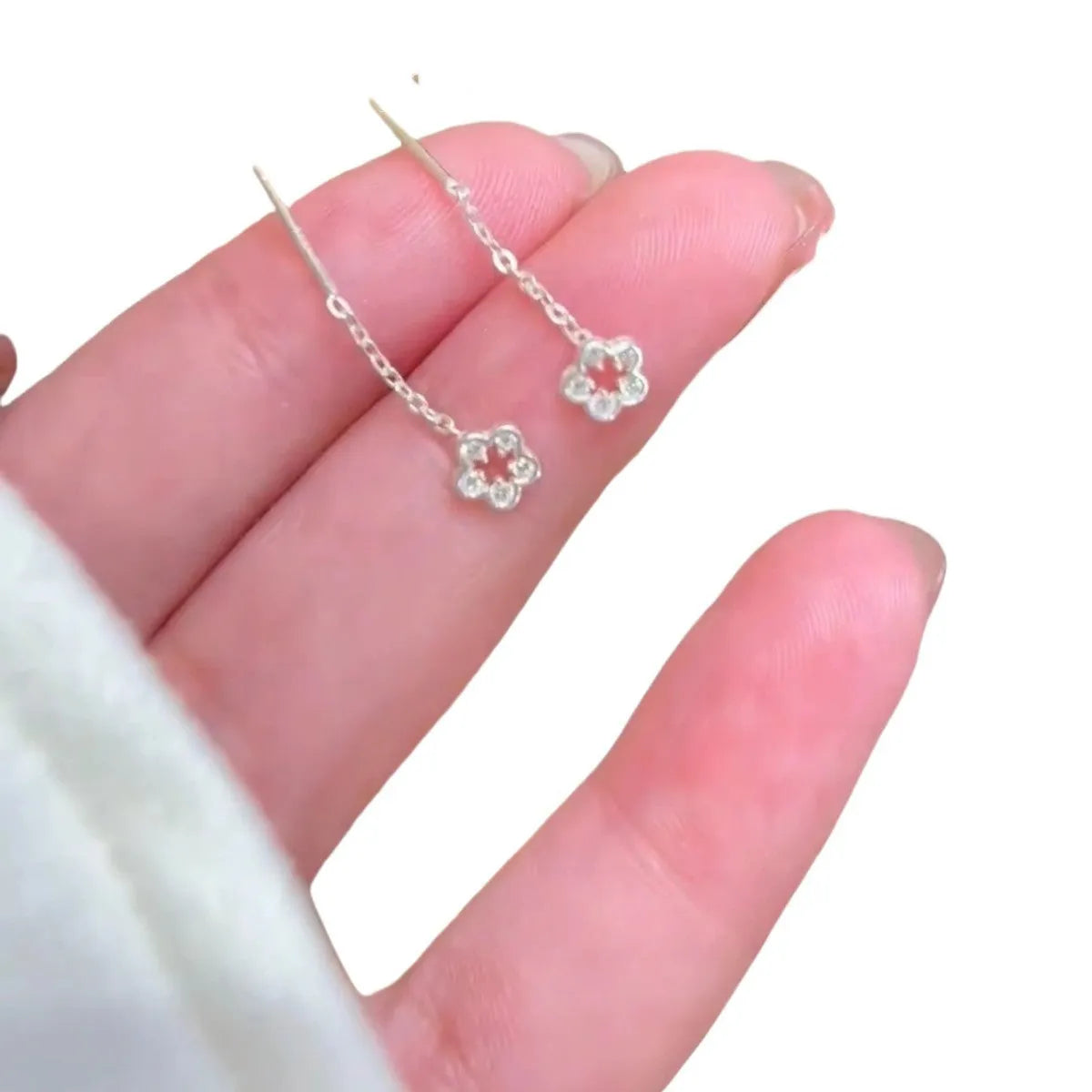 Pair of silver hollow flower dangle earrings with petal detail on alloy posts