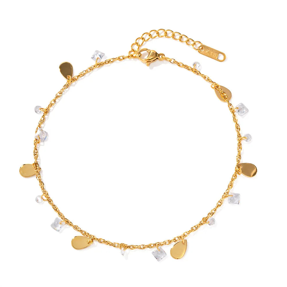 Close-up of a women's stainless steel anklet with a water drop pendant and tassel detail.