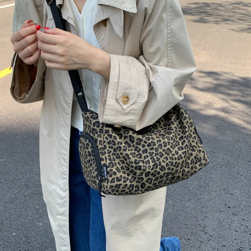 Sports-style cross-body messenger bag in leopard print pattern with decorative stitching details