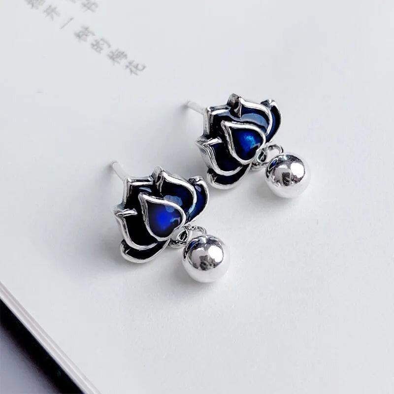 A pair of blue lotus ear studs with a seedpod and tassel design made from alloy.