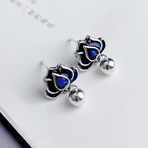 A pair of blue lotus ear studs with a seedpod and tassel design made from alloy.