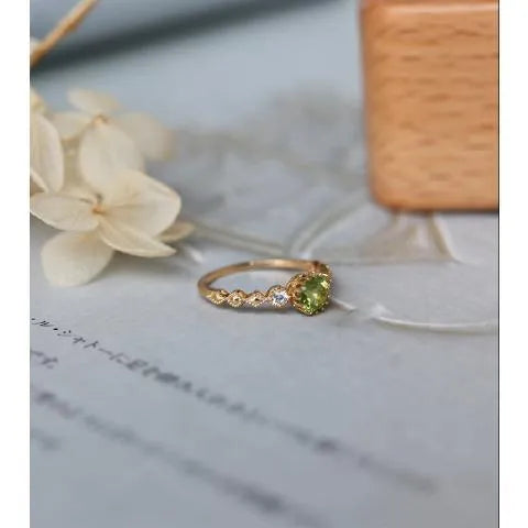 Close-up of a copper ring with a geometric quadrilateral shape and imitation peridot detail.