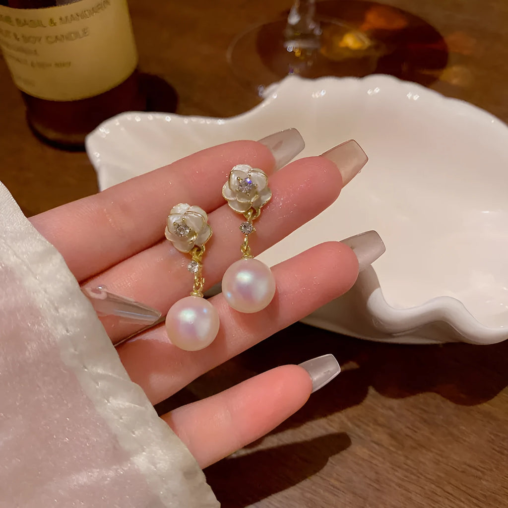 A pair of camellia flower-shaped stud earrings for women in a metallic alloy finish.