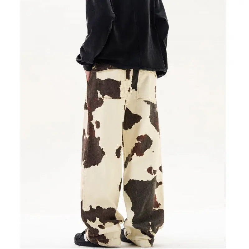 Men's straight-leg casual trousers with a blue and white American retro cow print pattern, showing button fly detail.