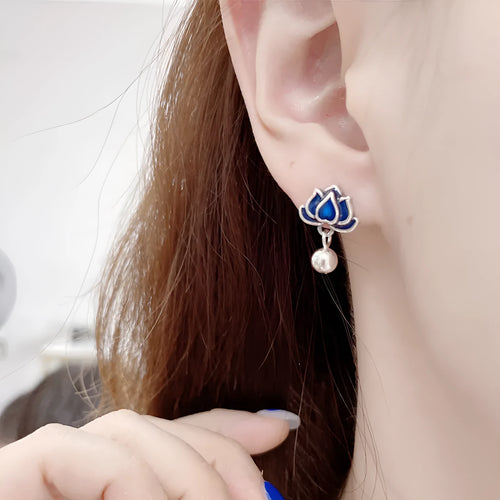 A pair of blue lotus ear studs with a seedpod and tassel design made from alloy.