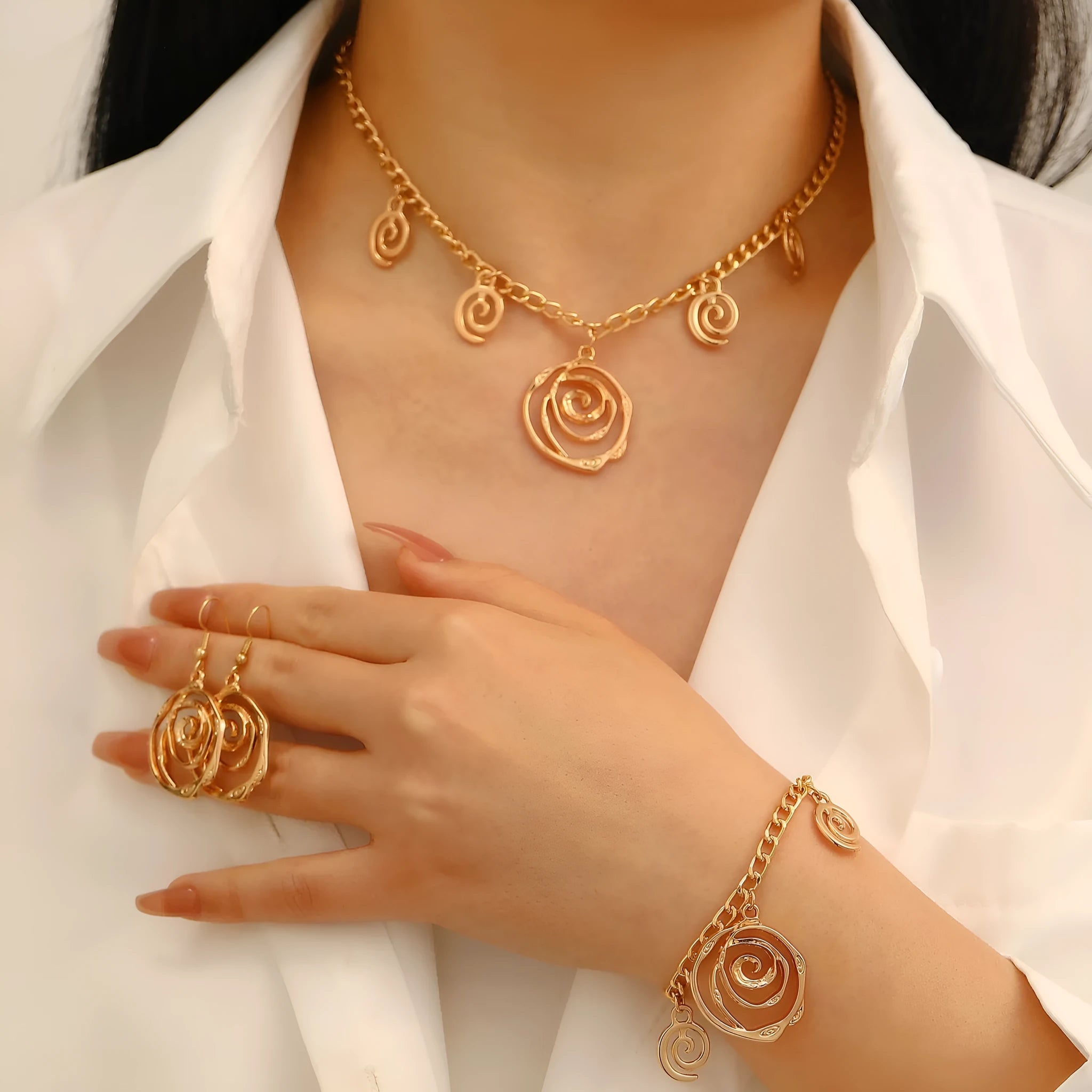 Gold or silver electroplated alloy jewellery set with spiral donut geometric shapes including necklace bracelet and ear hooks