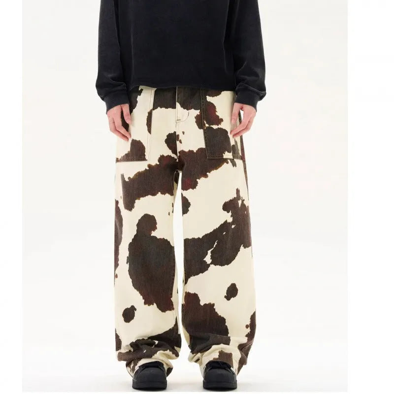 Men's straight-leg casual trousers with a blue and white American retro cow print pattern, showing button fly detail.