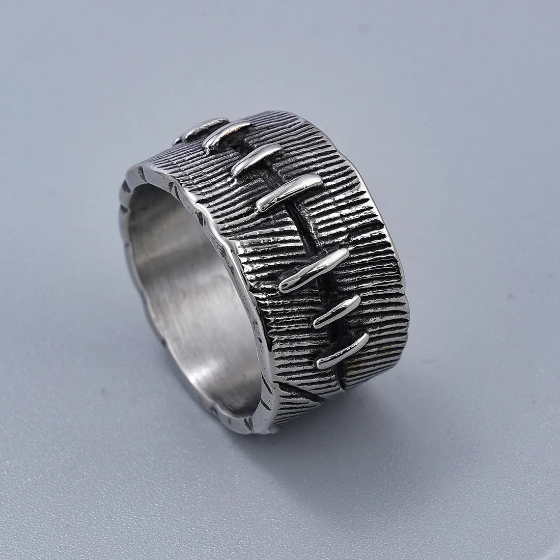 A geometric U-shaped dark punk double ring made from titanium steel in a retro colour, shown on a finger.