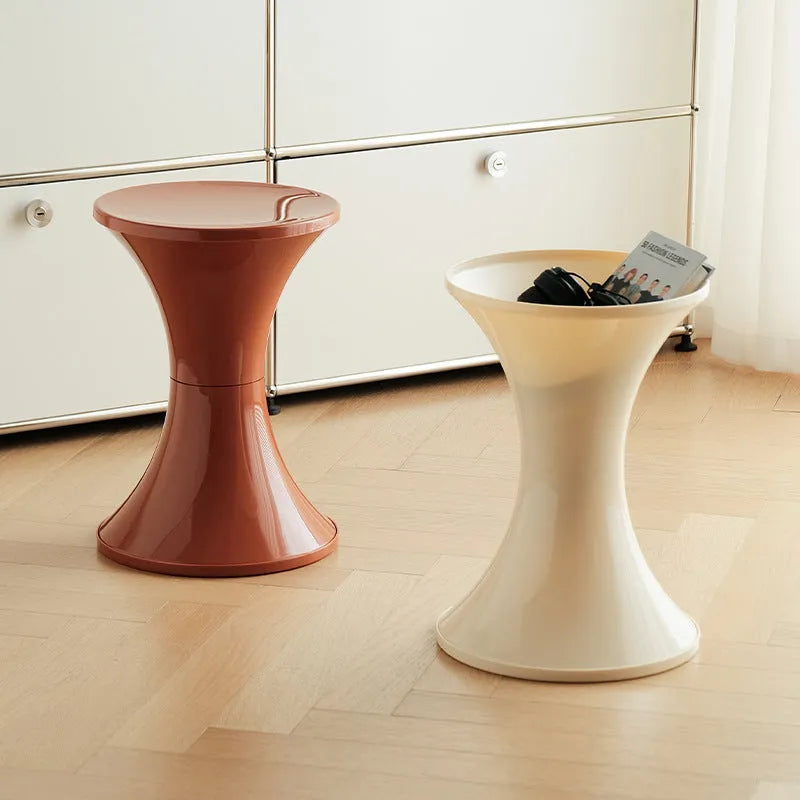 A plastic hourglass-shaped stool for changing shoes, shown in a green colour variant.