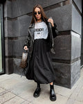 Women's solid colour long cotton skirt in black, shown with a structured fit suitable for casual or commute wear.