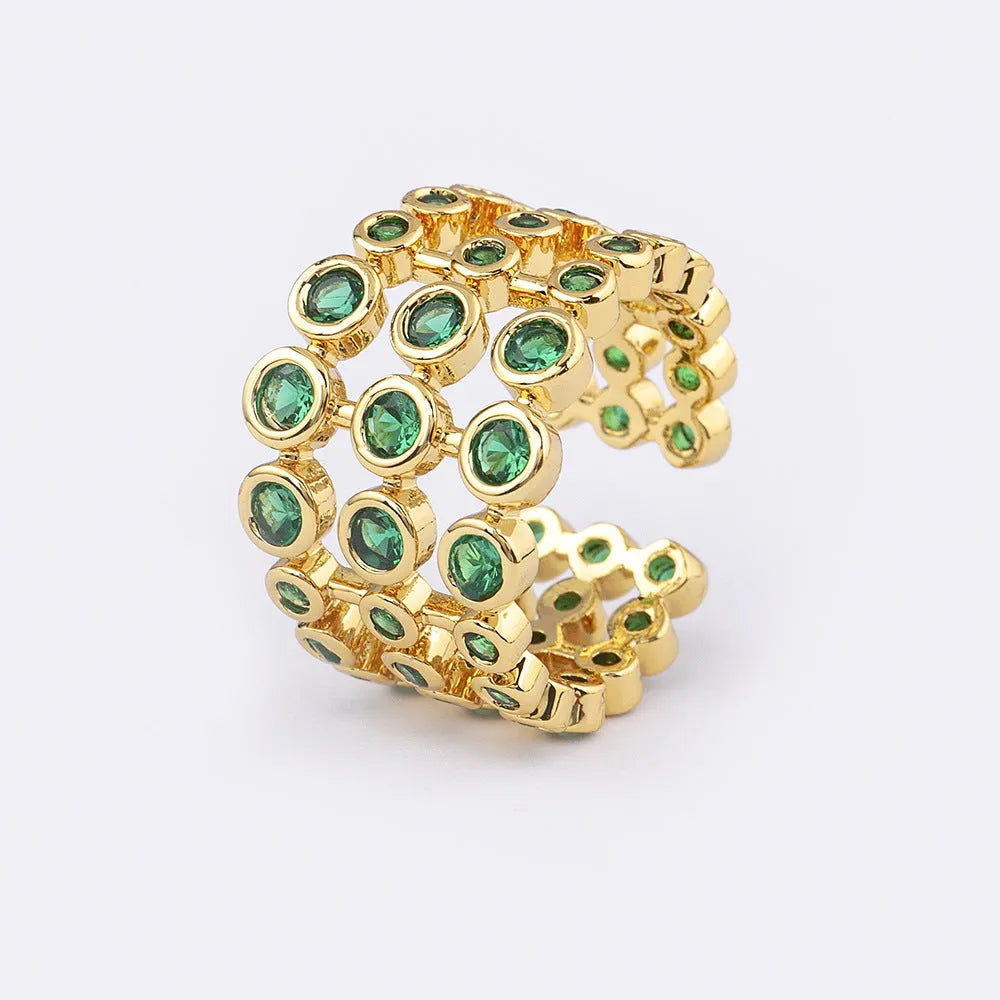 Copper ring with gold plating showing a wide, layered band fully set with green zircon stones.