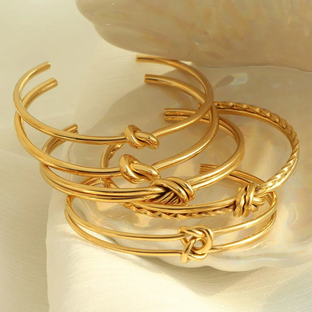 Women's adjustable stainless steel bracelet with C-shaped open design, double-layer construction and knotted detailing in gold or silver finish