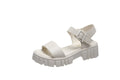 Women's beige peep toe platform sandals with an ankle-strap buckle on a wooden floor.