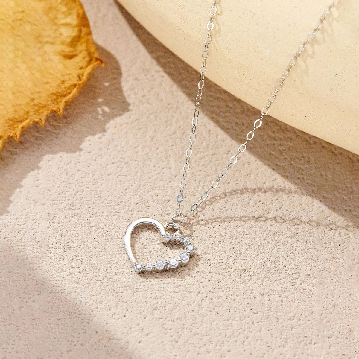S925 sterling silver hollow heart and circle pendant necklace on a regular chain, shown in two colour finishes.