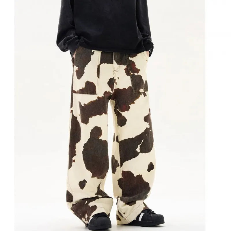 Men's straight-leg casual trousers with a blue and white American retro cow print pattern, showing button fly detail.