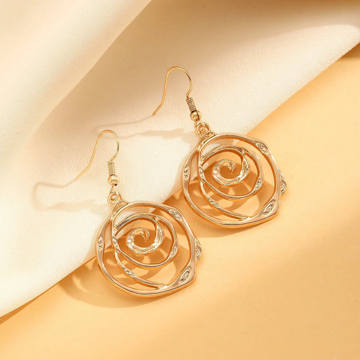 Gold or silver electroplated alloy jewellery set with spiral donut geometric shapes including necklace bracelet and ear hooks
