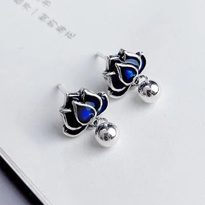A pair of blue lotus ear studs with a seedpod and tassel design made from alloy.