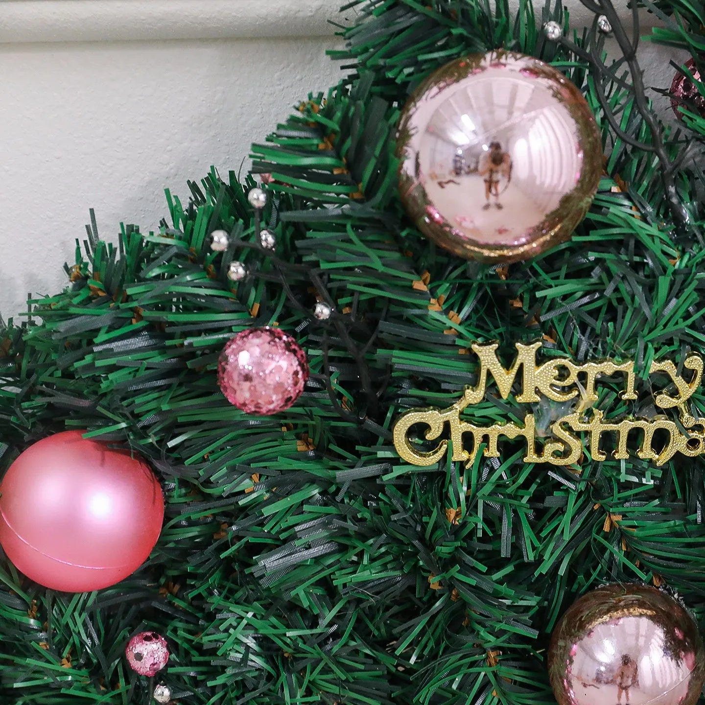 Long pink small fruit rattan Christmas garland draped over a stair bannister with optional LED lights